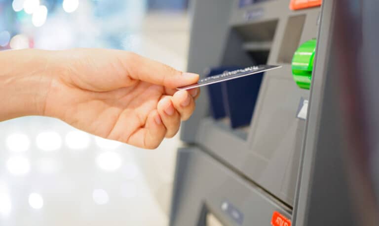 woman inserting debit card into atm
