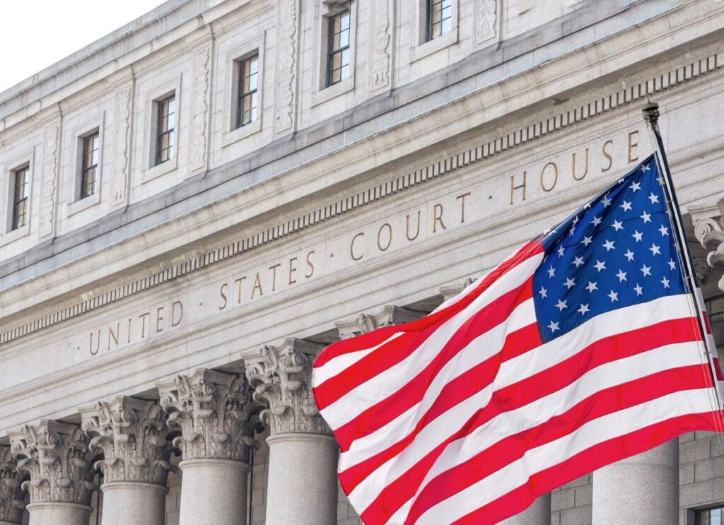 American flag waving in the wind in front of United States Court House in New York